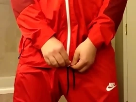 Returning in a red Nike windsuit